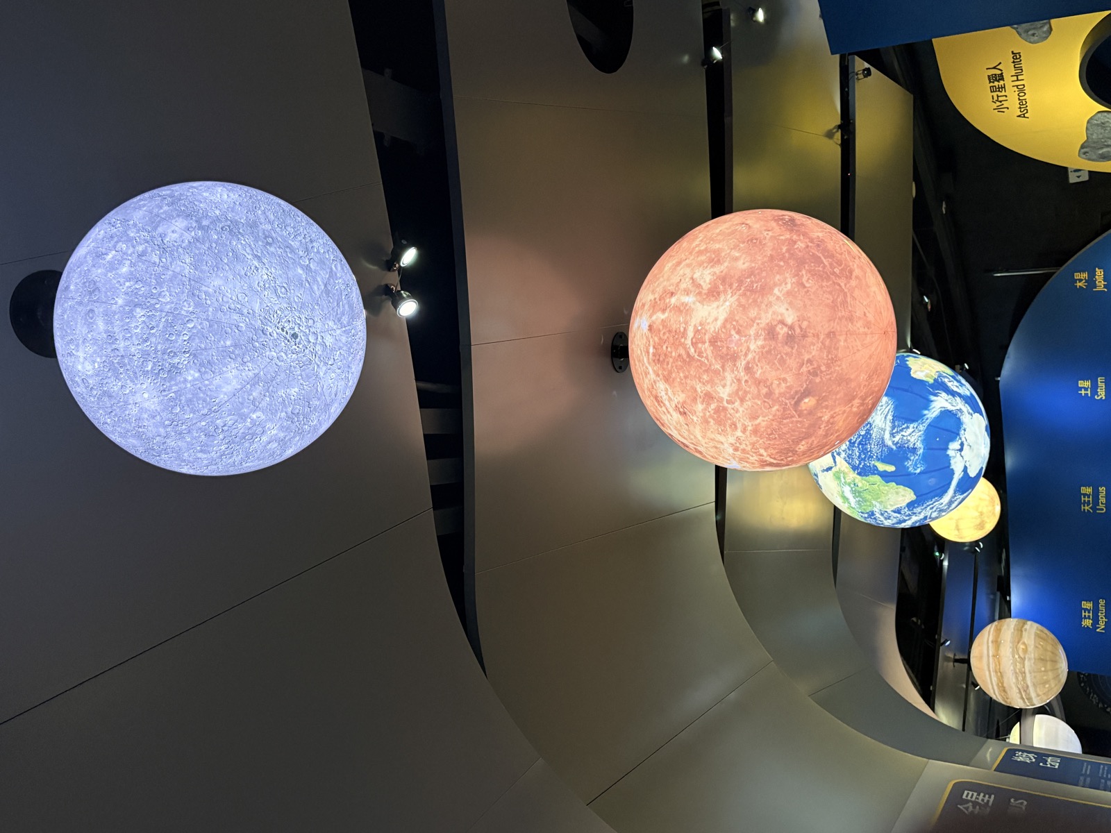 Illuminated planet models hanging in the solar-system hall of the Hong Kong Space Museum.